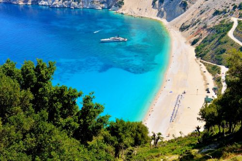 La plage de sable blanc de Myrtos sur l'île de Céphalonie en Grèce avec un luxueux superyacht à l'ancre