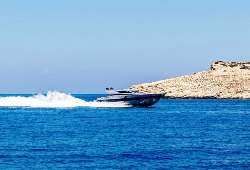 Un yacht  moteur sportif naviguant le long de la cte de Santorin