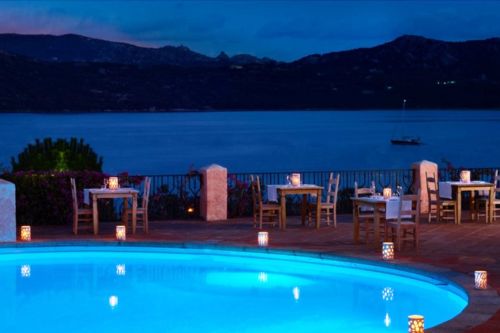 La piscine du restaurant Mira Luna avec vue sur la baie de Cannigione et quelques tables dresses pour le dner