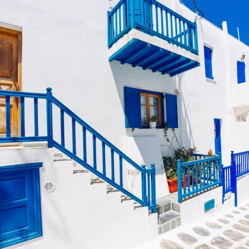 Une ruelle de Mykonos avec des bâtiments blanchis et des détails bleus typiques des îles Cyclades en Grèce