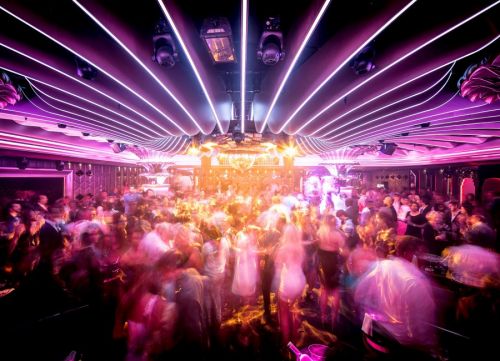 Ambiance de fête et gens qui dansent aux Caves du Roy, la boite de nuit du mythique hôtel Byblos à Saint-Tropez