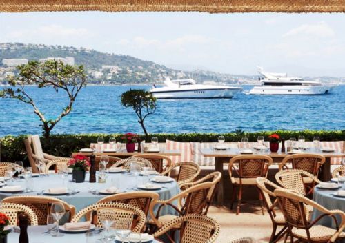 Des tables sont installes pour le djeuner sur la terrasse de La Gurite  Cannes avec des yachts au mouillage