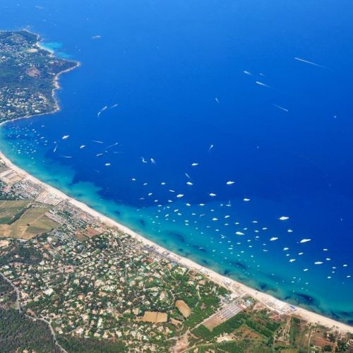 La plage de sable de Pampelonne  Ramatuelle, prs de Saint-Tropez, et des luxueux yachts de location  l'ancre