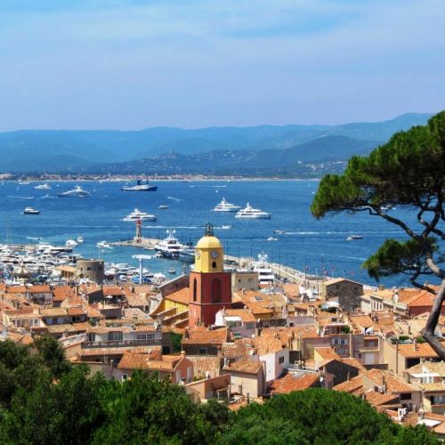 Vue du village de Saint-Tropez avec son clocher et des yachts de location  l'ancre dans la baie