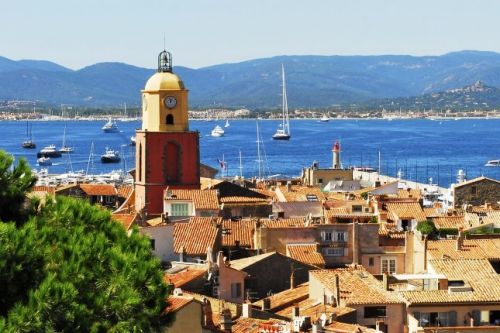 Panorama du village de Saint-Tropez avec son clocher et des yachts  l'ancre dans la baie