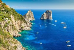 Panorama aérien des formations rocheuses des Faraglioni au large de l'île de Capri avec une multitude de yachts à l'ancre