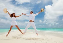 Un couple heureux en lune de miel sautant sur une plage