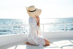 Une femme avec un chapeau prenant le soleil pendant sa lune de miel à bord d'un yacht