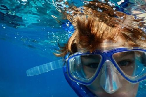 Un garon faisant du snorkeling avec masque et tuba