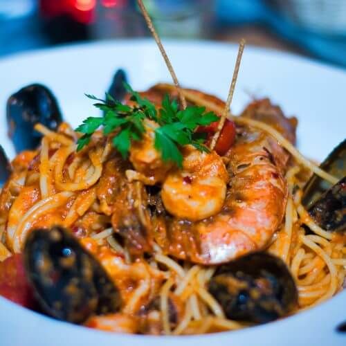 Une assiette de ptes aux fruits de mer avec des moules dans un restaurant au bord de l'eau