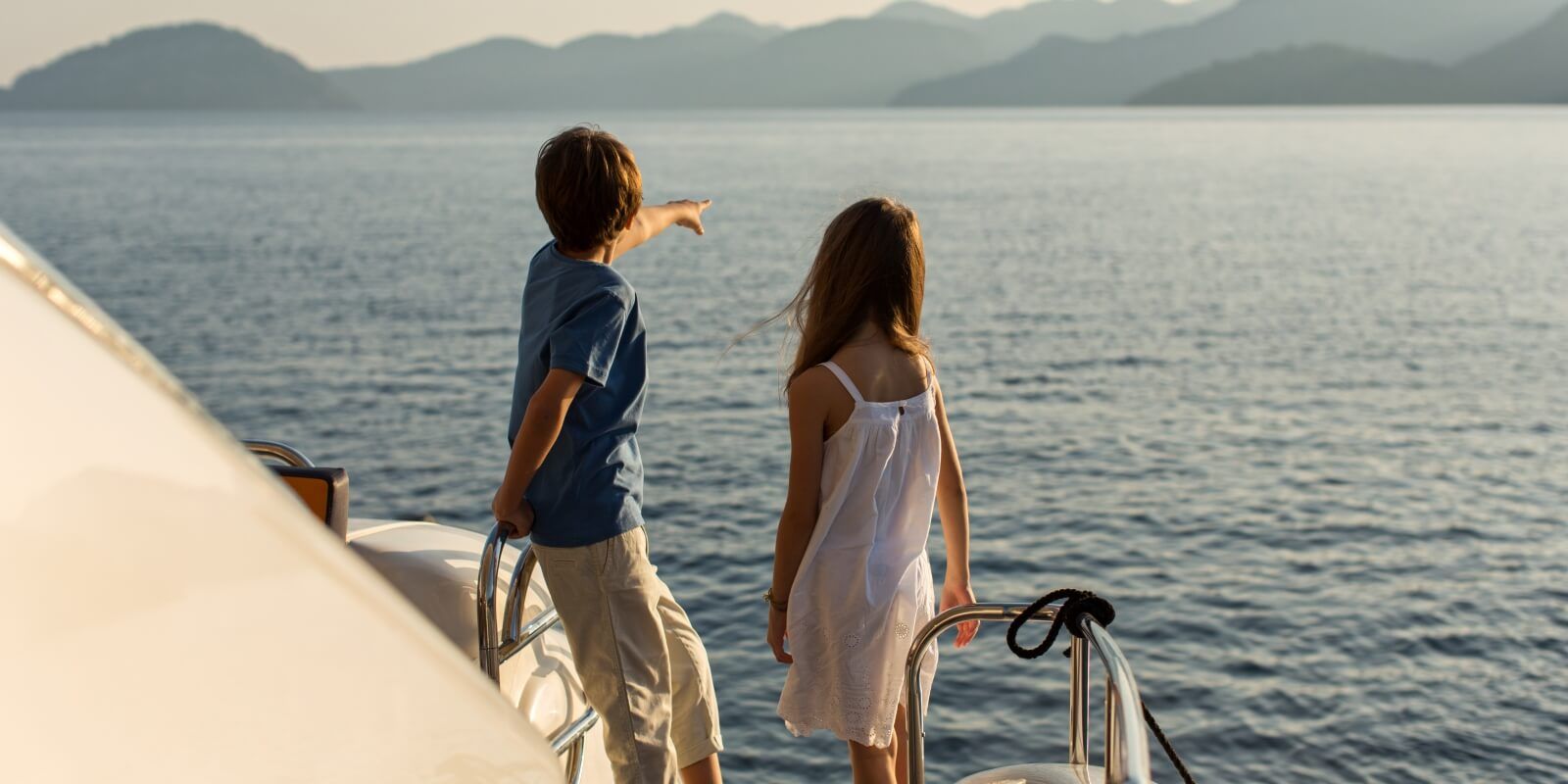 https://www.talamare.fr/medias/Des enfants regardant la mer depuis un yacht de location avec leurs parents sur le pont arrire