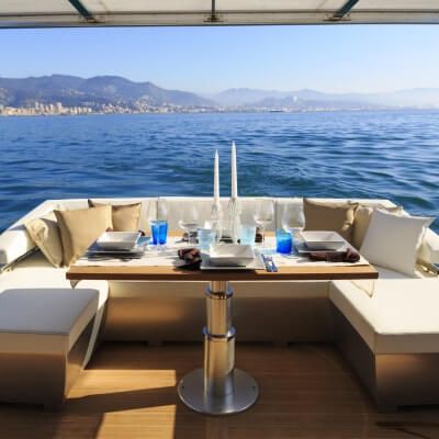 Une table dresse pour le djeuner sur le pont arrire d'un yacht de location de luxe disponible sur la Cte d'Azur