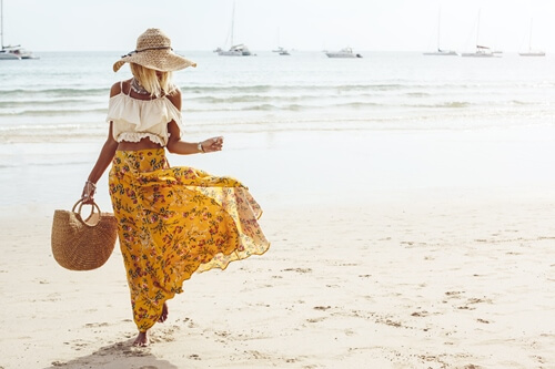 Une femme portant des vtements tendance marchant sur la plage