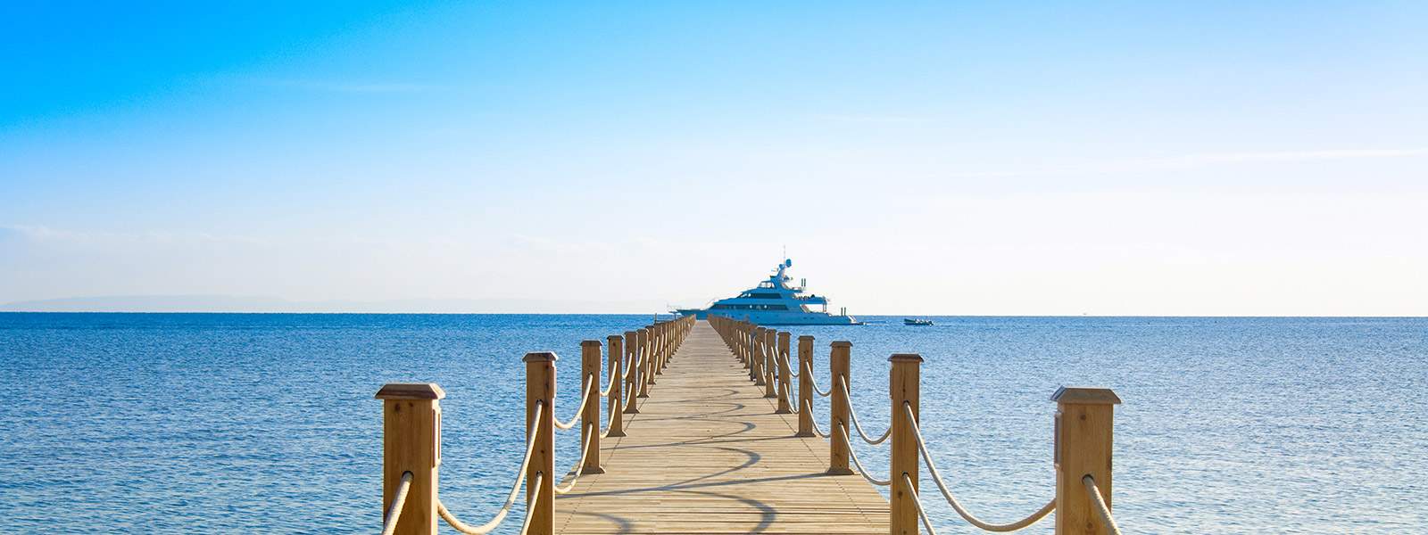 Un ponton en bois avec un yacht de location prt  accueillir les charter guests